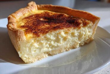 A close-up slice of amazing custard pie showing the thick, creamy filling and a golden, caramelized top.