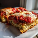 Two baked slices of low-calorie eggplant parmesan topped with rich marinara sauce and melted mozzarella cheese.