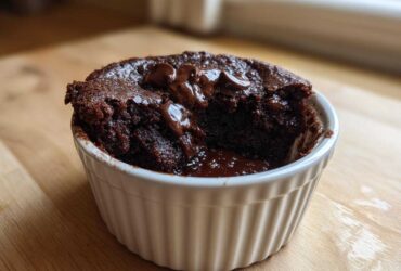 A rich, dark chocolate Cottage Cheese Microwave Brownie served warm in a white ramekin with melted chocolate chips.