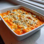 Close-up of hot, bubbly Buffalo chicken dip topped with melted cheese and blue cheese crumbles.