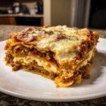 A thick, layered slice of Lasagna with Cottage Cheese, topped with melted cheese and meat sauce.