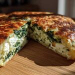 Close-up of a thick, golden-brown Mediterranean Spinach and Feta Cheese Crisps, showing the rich filling of spinach and feta.