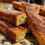 Close-up of golden brown Air Fryer French Toast Sticks heavily coated in cinnamon sugar.