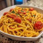 A close-up of creamy Baked Feta Pasta with Cherry Tomatoes tossed in a white bowl.