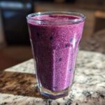 Close-up of a vibrant, thick Blueberry Lemon Chia Smoothie packed with visible chia seeds.