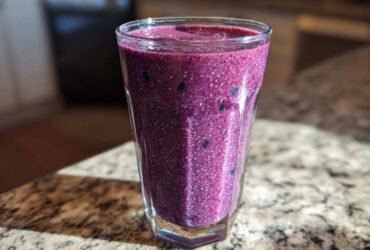 Close-up of a vibrant, thick Blueberry Lemon Chia Smoothie packed with visible chia seeds.