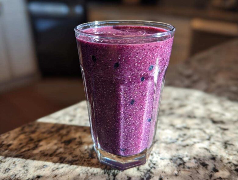Close-up of a vibrant, thick Blueberry Lemon Chia Smoothie packed with visible chia seeds.