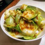 Close-up of Cabbage Stir Fry with Garlic Ginger Sauce, featuring bright green cabbage wedges coated in a savory brown sauce.