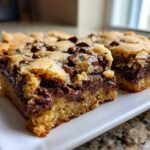 Two squares of incredibly chewy chocolate chip cookie bars showing melted chocolate centers.