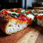 Close-up of a thick, chewy crust Gluten-Free Margherita Pizza slice showing airy interior and fresh toppings.