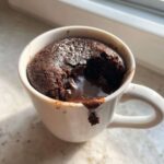 Close-up of a freshly baked Chocolate Lava Mug Cake with molten chocolate oozing out of the center.