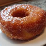 A close-up of a perfectly cooked, golden Cinnamon Sugar Air Fryer Donut coated in glistening sugar.