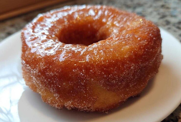 A close-up of a perfectly cooked, golden Cinnamon Sugar Air Fryer Donut coated in glistening sugar.