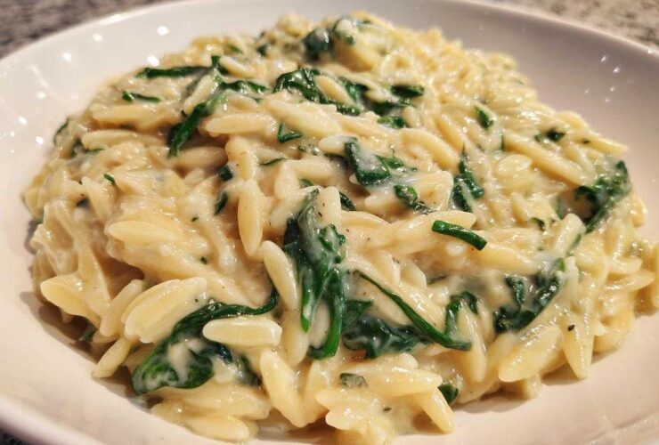 A close-up view of a bowl filled with rich Creamy Garlic Parmesan Orzo with Spinach.