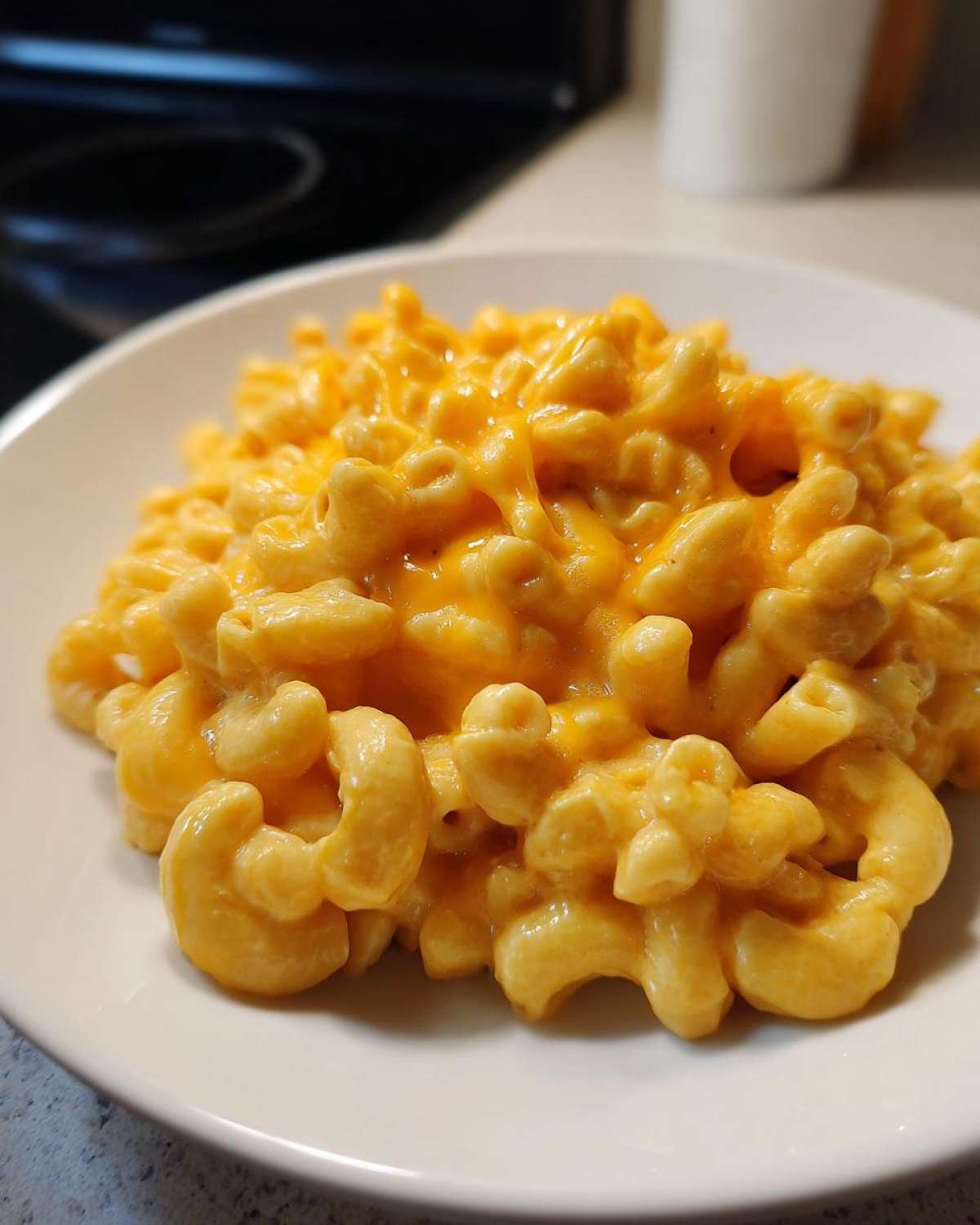 A close-up of creamy, cheesy Instant Pot Mac and Cheese served on a white plate.