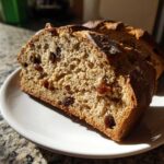 Close-up of two thick slices of Easy Irish Soda Bread with Buttermilk and Raisins on a white plate.