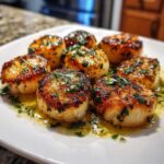 Close-up of seared Garlic Butter Scallops with Lemon, glistening in butter sauce and topped with parsley.