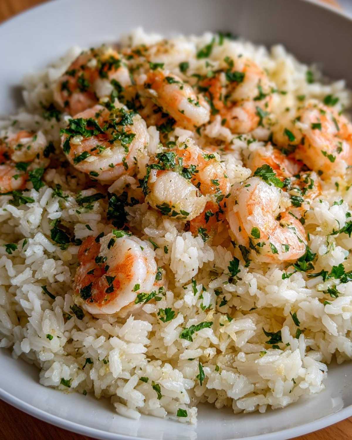 Close-up of fluffy white rice topped with succulent shrimp coated in garlic butter and fresh parsley, a perfect Garlic Butter Shrimp and Rice Skillet.