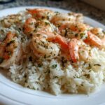 Close-up of plump, seasoned shrimp served over fluffy white rice in a Garlic Butter Shrimp and Rice Skillet dish.