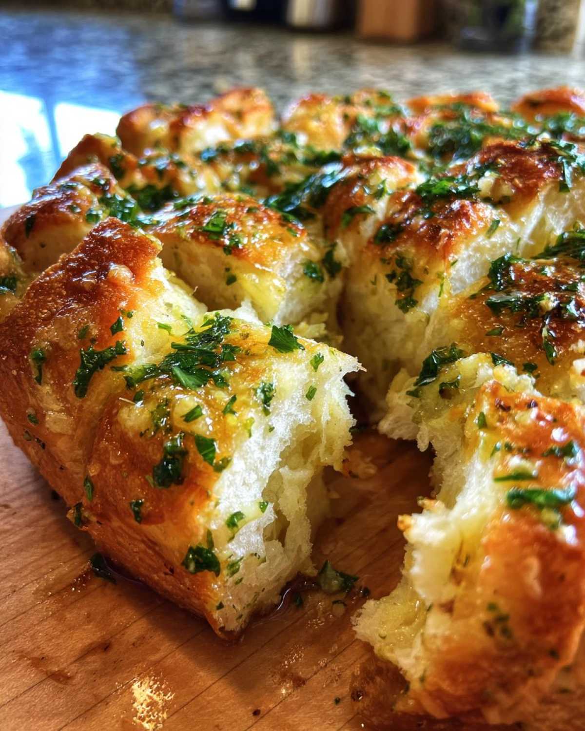 Close-up of golden brown Garlic Parmesan Pull-Apart Bread, glistening with butter and topped with fresh parsley.