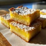 Close-up of stacked Gluten-Free Lemon Bars with shortbread crust, dusted generously with powdered sugar.