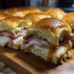 Close-up of freshly baked Hawaiian Roll Ham and Cheese Sliders oozing melted cheese and honey mustard glaze.