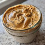 Close-up of High-Protein Peanut Butter Overnight Oats topped with a swirl of peanut butter and sprinkled chia seeds.