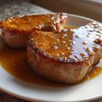 Two thick slices of Honey Glazed Ham Steak in the Skillet, glistening with sweet brown glaze on a white plate.