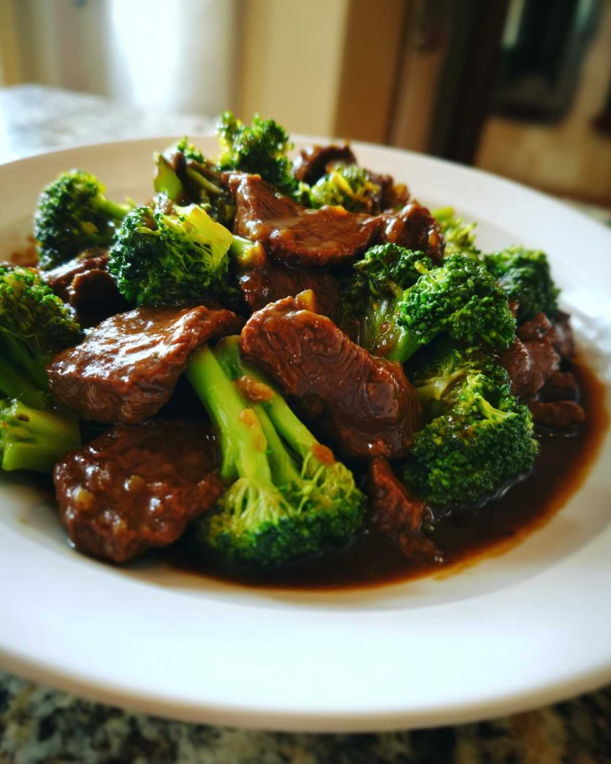 Close-up of tender beef slices and bright green broccoli florets coated in savory sauce, ready to eat Instant Pot Beef and Broccoli.