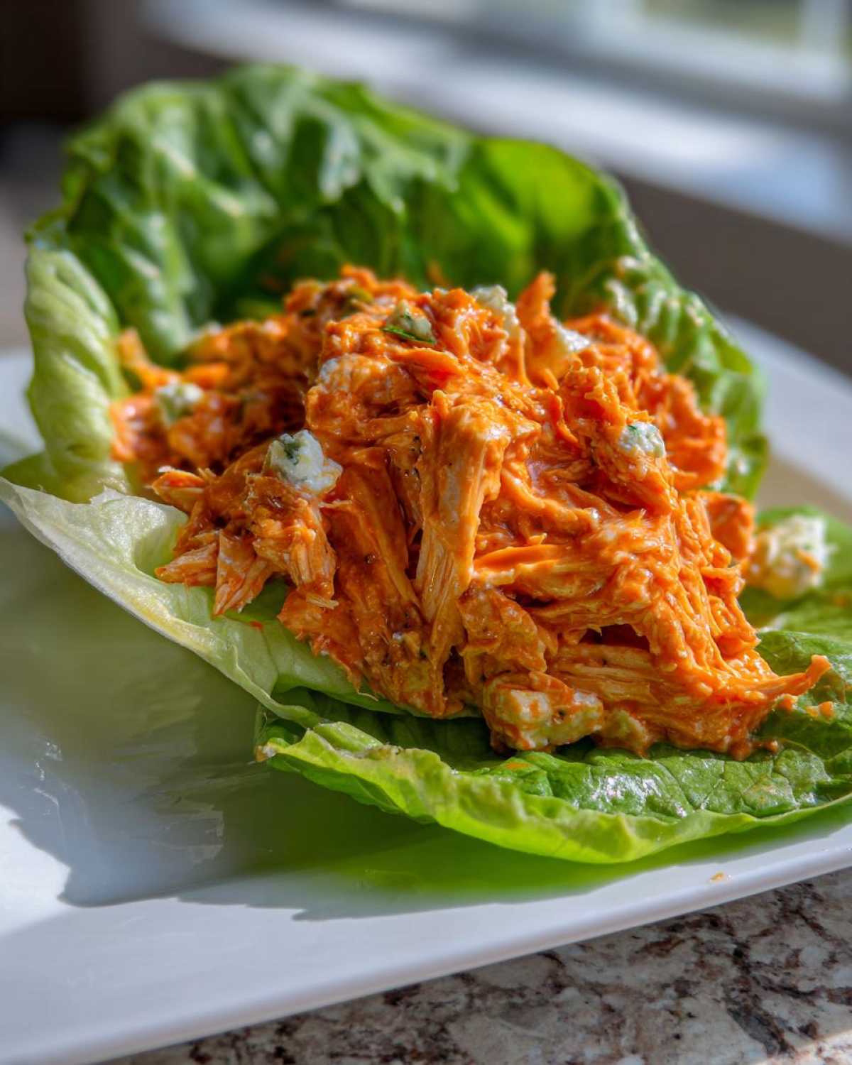 Close-up of Keto Buffalo Chicken Lettuce Wraps filling served in a crisp butter lettuce cup.