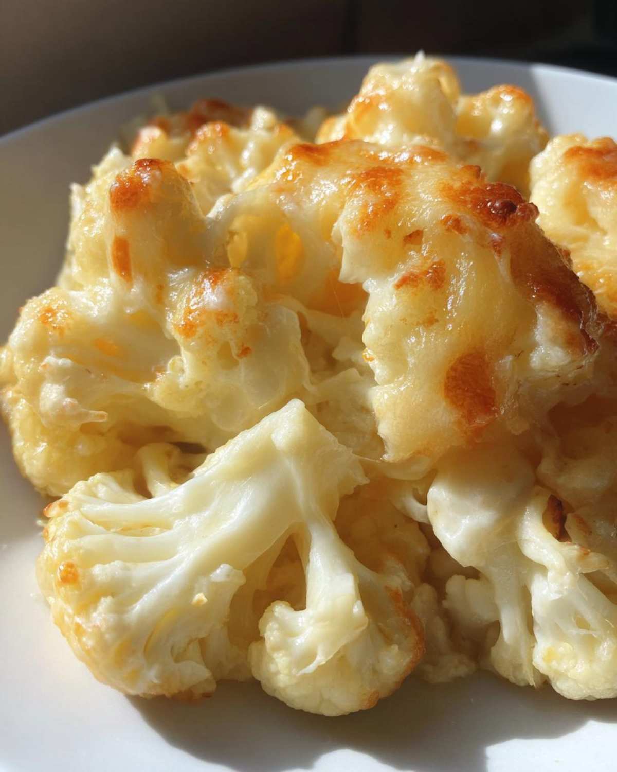 Close-up of tender cauliflower florets baked in a rich, bubbly cheese sauce, perfect for Keto Cauliflower Mac and Cheese.