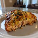 Close-up of a perfectly cooked piece of Keto Garlic Butter Salmon with a golden, cheesy crust and fresh parsley.