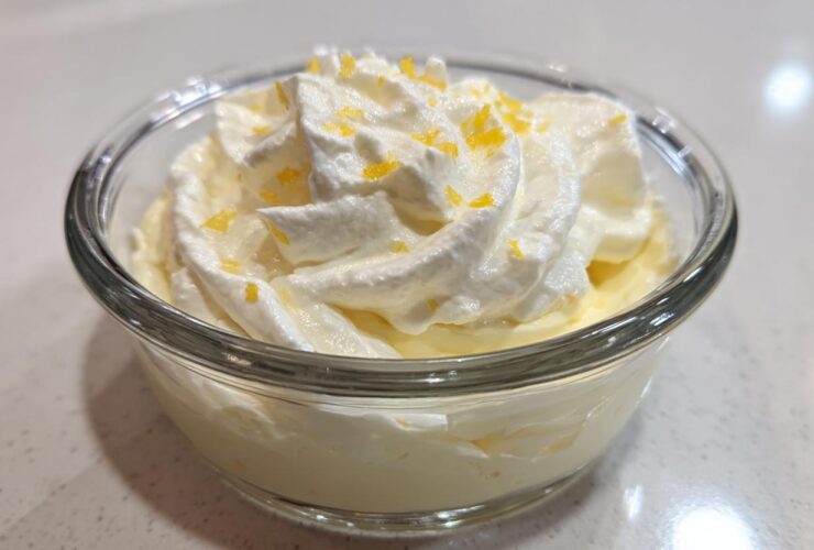Close-up of single serving Keto Lemon Cheesecake Mousse topped with whipped cream and lemon zest.