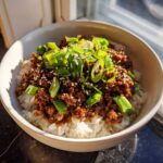 A close-up of Korean Ground Beef Bulgogi Bowls featuring savory ground beef over white rice, topped with fresh green onions and sesame seeds.