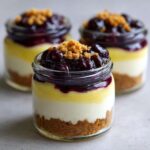 Close-up of individual Lemon Blueberry Cheesecake Jars showing graham cracker crust, cream cheese, lemon curd, and blueberry topping.