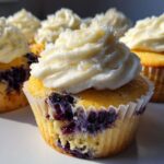 Close-up of Lemon Blueberry Cupcakes topped with swirls of white cream cheese frosting.