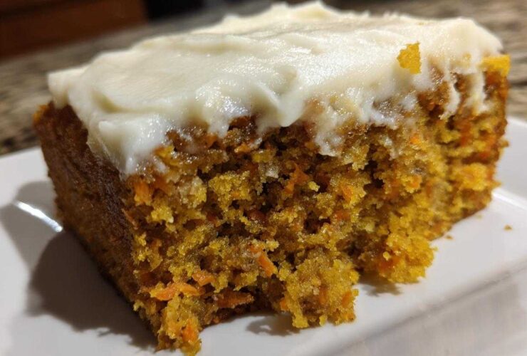 Close-up of a very moist carrot cake with cream cheese frosting showing the texture.