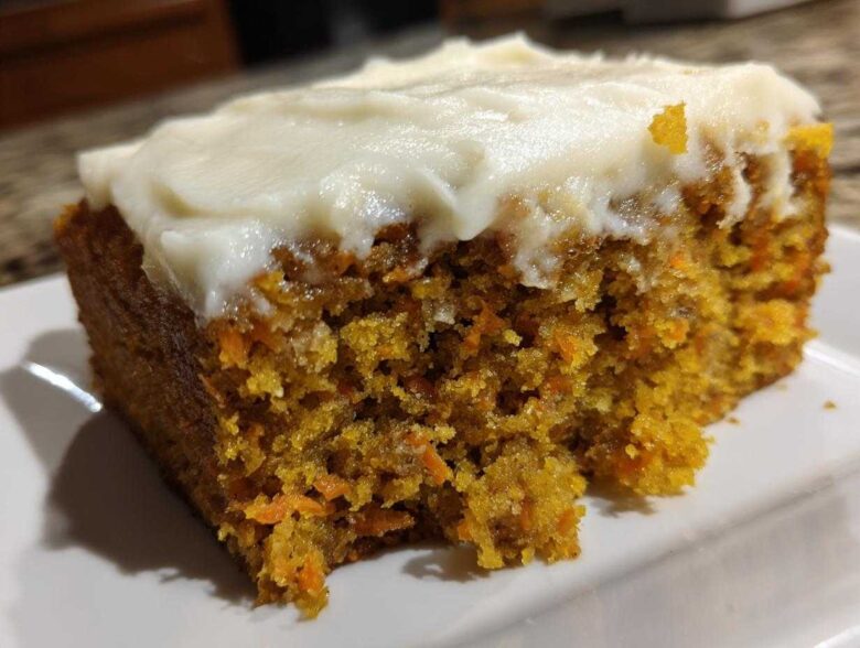 Close-up of a very moist carrot cake with cream cheese frosting showing the texture.