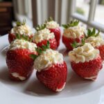 Close-up of several No-Bake Cheesecake Stuffed Strawberries arranged on a white plate.