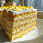 Close-up of a layered slice of No-Bake Lemon Icebox Cake showing creamy filling and graham cracker layers.