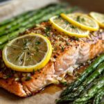 Close-up of a perfectly cooked One-Pan Lemon Garlic Salmon with asparagus spears and lemon slices.