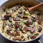 Close-up of rich One-Pot Creamy Mushroom Orzo topped with sautéed mushrooms and fresh parsley.