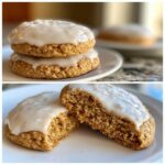 Two stacked Soft-Baked Carrot Cake Cookies topped with thick cream cheese glaze, and one cookie broken open showing the soft interior.