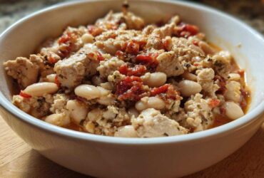 Close-up of Spicy Turkey White Bean Chili featuring ground turkey, white beans, and diced tomatoes in a white bowl.