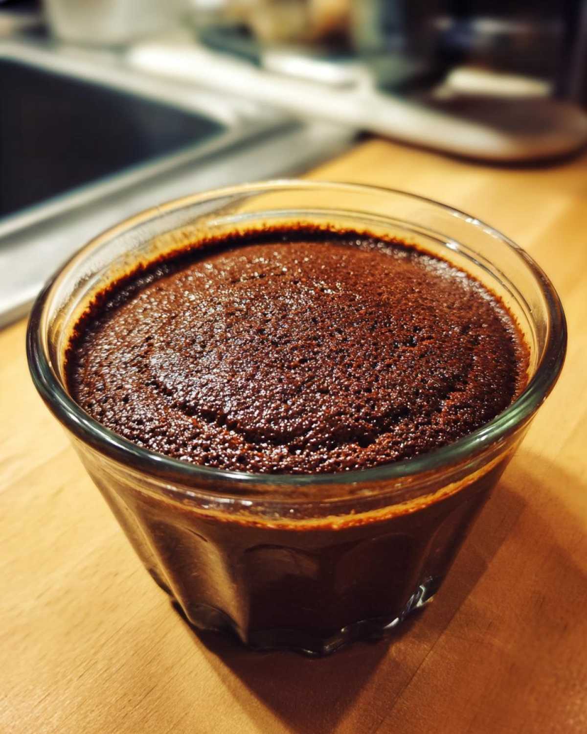 Close-up of rich, dark Vegan Chocolate Avocado Mousse set in a small, clear glass serving dish.