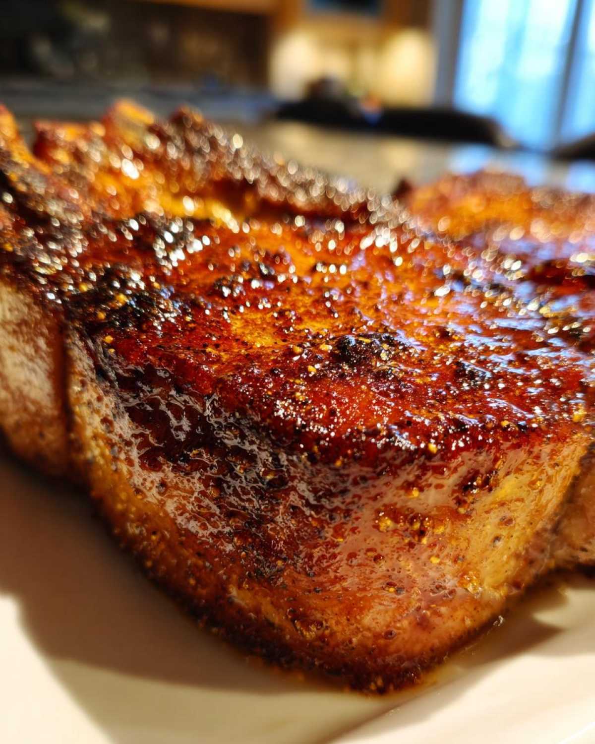 Macro shot showing the beautifully caramelized and seasoned crust of an air fryer pork chop.