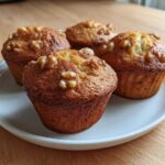 Four freshly baked Banana Walnut Cottage Cheese Muffin Breakfast items displayed on a white plate.