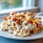 Close-up of a creamy serving of Chicken Bacon Ranch Casserole topped with shredded chicken, melted cheese, and crispy bacon bits.