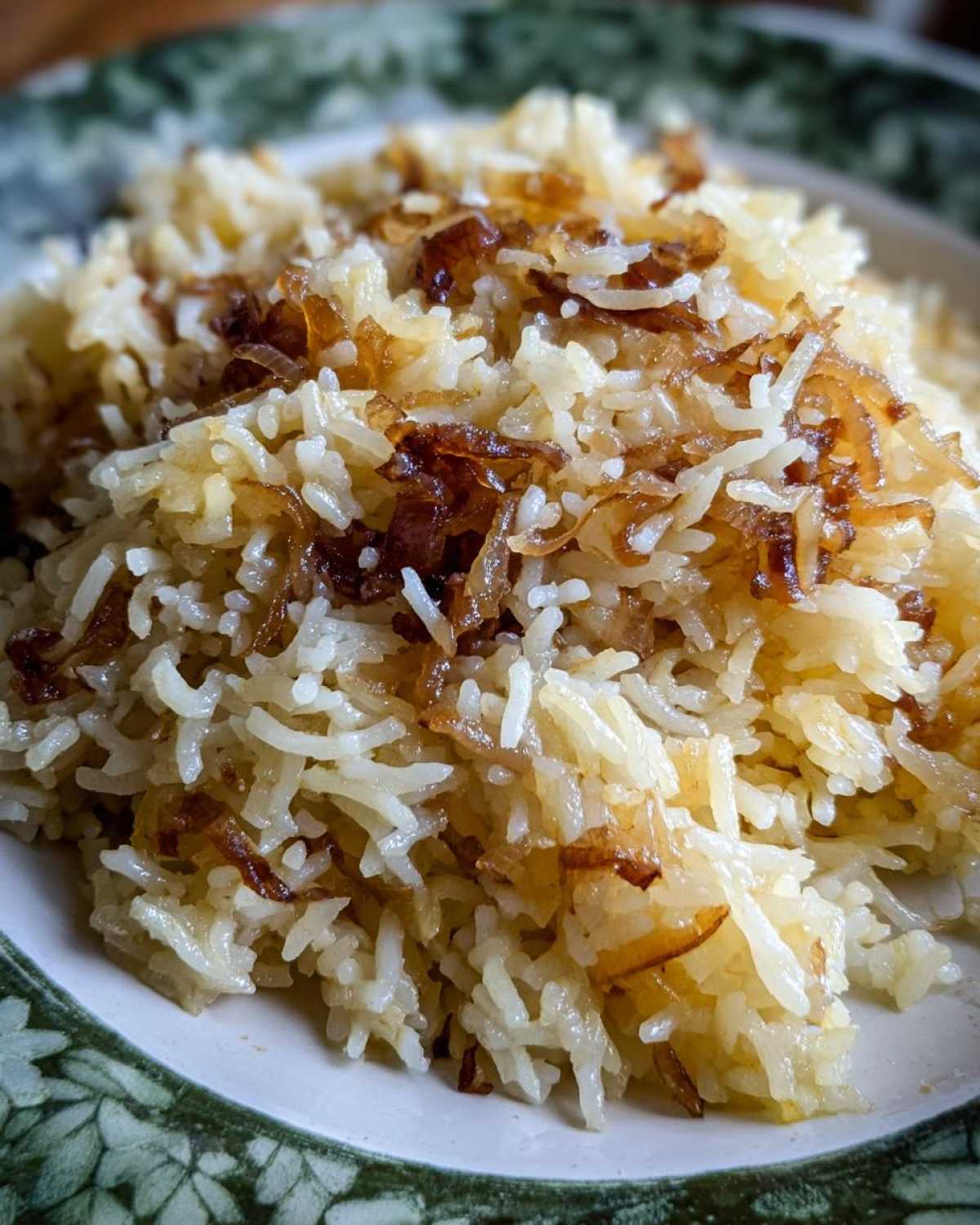 A close-up view of fluffy white rice topped generously with deeply caramelized, crispy french onion butter rice topping.
