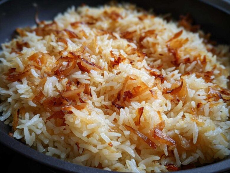 A close-up shot of fluffy white rice topped generously with crispy, caramelized onions, showcasing the french onion butter rice.